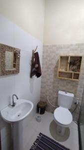 a bathroom with a white toilet and a sink at Paraíso da falésia em Cumuruxatiba com vista excepcional para o mar in Cumuruxatiba