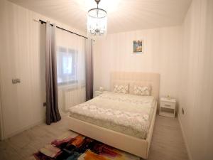 a bedroom with a bed and a chandelier at ASE Premium House in Suceava
