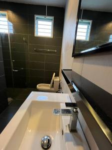 een badkamer met een wastafel, een toilet en een spiegel bij Nice semi D house at Tangkak in Tangkak