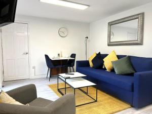 a living room with a blue couch and a table at Langley Bungalow in Slough