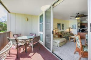 een woonkamer met een tafel en stoelen en een bank bij "Sea Breeze" at Wailua Bay View in Kapaa