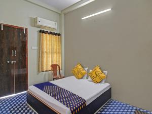 a bedroom with a bed with yellow and blue sheets at OYO Hotel G.K Lodging and Guest House in Sakardarā