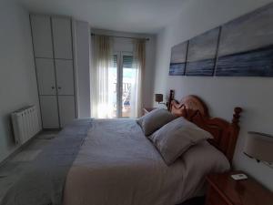 a bedroom with a large bed and a window at Primera línea de Playa in Almuñécar