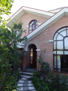 a brick house with a staircase leading to the front door at House garden airport in Zamacola