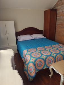 Schlafzimmer mit einem Bett mit blauer Decke in der Unterkunft House garden airport in Zamacola
