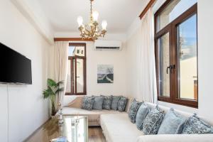 a living room with a white couch and a chandelier at Casa Di Sofia in Rethymno Town