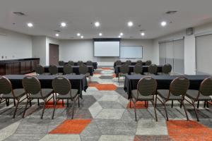 a conference room with tables and chairs and a screen at Comfort Suites Arlington - Entertainment District in Arlington