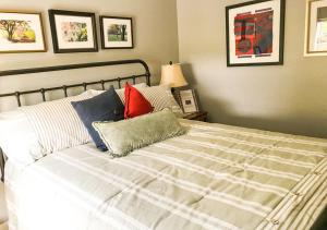 1 dormitorio con cama blanca y almohadas coloridas en Glenn Meadow Bed and Breakfast, en South Haven