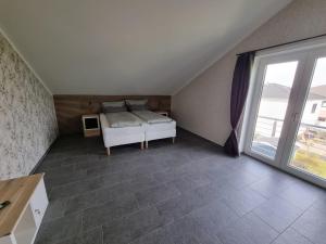 um quarto com uma cama e uma grande janela em Ambiente Feriendomizil em Weilerswist
