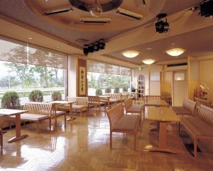 富士河口湖的住宿－丸榮日式旅館，餐厅设有桌椅和大窗户。