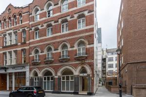 een zwarte auto geparkeerd voor een bakstenen gebouw bij Luxury 2 bedroom flat in Holborn in Londen