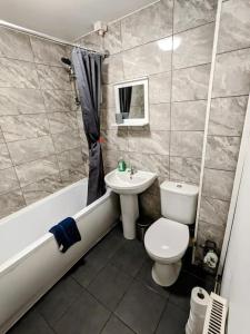 W łazience znajduje się umywalka, toaleta i wanna. w obiekcie K Suites - Harrogate Terrace w mieście Bradford