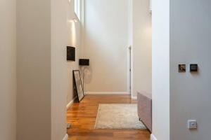 a hallway with white walls and wooden floors at Luxury 2 bedroom flat in Holborn in London