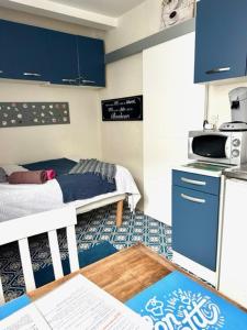 a small kitchen with a bed in a room at Petit studio plage Le galet bleu in Le Havre