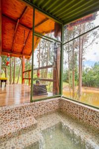 Cabaña Tipo Glamping Savieza Life Experience في Nemocón: حمام سباحة داخلي في منزل مع نوافذ زجاجية