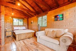 a bedroom with a bed and a couch in a room at Cabaña Tipo Glamping Savieza Life Experience in Nemocón