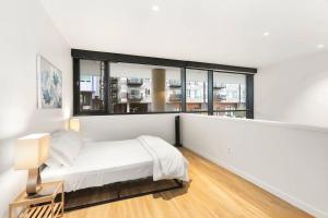 1 dormitorio con cama y ventana grande en Urban Loft, Redmond Core - 92 Walkscore! en Redmond