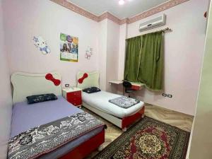a bedroom with two beds and a window at Bright And Vintage 3 BR Suite in Cairo