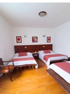 3 camas en una habitación con suelo de madera en La Molienda Casa Hotel, en San Agustín