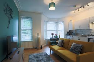 a living room with a couch and a kitchen at The best flat on the street - Three minutes walk from the beach in Southend-on-Sea