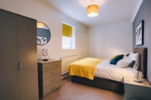 Schlafzimmer mit einem Bett, einer Kommode und einem Spiegel in der Unterkunft The best flat on the street - Three minutes walk from the beach in Southend-on-Sea