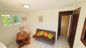 sala de estar con sofá y mesa en Eden Part' - Appartement avec jardin privé à Baie-Mahault, en Baie-Mahault