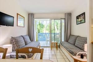 ein Wohnzimmer mit 2 Sofas und einem Balkon in der Unterkunft Village Moliets - maeva Home - Appartement 2 Pièces 5 Personnes Confort MAE-4322 in Moliets-et-Maa