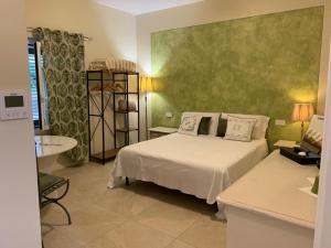 a bedroom with a white bed and a green wall at Villa Marta bed and breakfast in Gussago