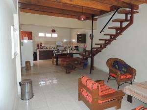 a kitchen and a living room with a spiral staircase at Hostal Dinosaurio in Torotoro