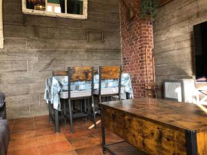 a table and chairs in a room with a brick wall at Sierra Nevada Galatino 22E in Sierra Nevada