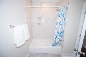 a white bathroom with a shower with a shower curtain at The Josi:Elegant space and view in Washington, D.C.