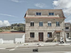 a stone house on the side of a street at Apartamento Albar in Poio