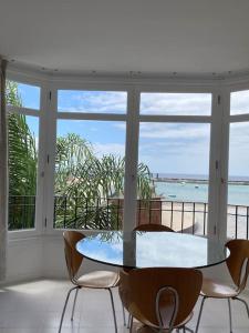 a table and chairs in a room with a view of the ocean at Sea&Harbour Arrecife in Arrecife