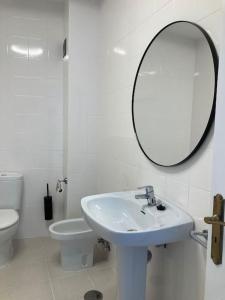 a white bathroom with a sink and a mirror at Sea&Harbour Arrecife in Arrecife