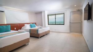 a hotel room with two beds and a window at Portobelo Boulevard in San Andrés