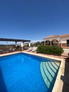 a large blue swimming pool in a yard at Villa Azafran in Málaga