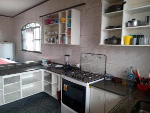 a kitchen with white cabinets and a stove top oven at Quartos Econômicos in Manaus