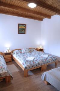 1 dormitorio con 2 camas y 2 mesitas de noche en Füzesi Papa Vendégháza, en Harta