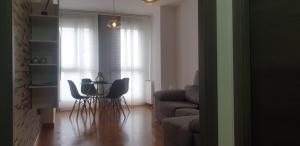 una sala de estar con una mesa, sillas y un sofá en Apartamento tranquilo, en Ponferrada