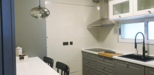 Una cocina con fregadero y una mesa con sillas. en Apartamento tranquilo, en Ponferrada
