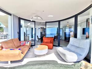 a living room with couches and chairs and windows at Vue sur mer La Baule Soléa in La Baule