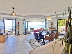 a dining room and living room with a table and chairs at Vue sur mer La Baule Soléa in La Baule