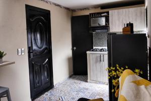 uma cozinha com uma porta preta e um frigorífico em Confortable apartamento en Bello Ant. em Bello