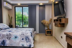um quarto com uma cama e uma grande janela em Confortable apartamento en Bello Ant. em Bello