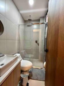 een badkamer met een douche, een toilet en een wastafel bij Suite Moderna Con Coworking,Centro Historico in Cuenca