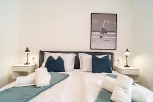 - une chambre dotée d'un grand lit avec des oreillers bleus et blancs dans l'établissement A Apartments, à Zadar