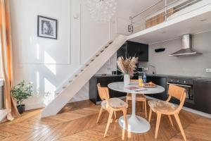 a kitchen with a table and chairs and a staircase at Central Modern Loft with Balcony! #Historic building #Smart TV #Fast Wi-Fi #Metro in Warsaw