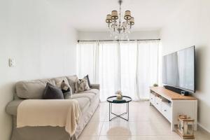 ein Wohnzimmer mit einem Sofa und einem Flachbild-TV in der Unterkunft Relax Apartment to enjoy! in Santiago de los Caballeros