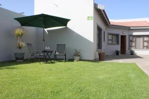d'une terrasse avec une table et une pelouse verdoyante. dans l'établissement 4499 Desert Rose, à Swakopmund