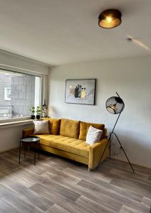 a living room with a yellow couch and a window at Zentrales Apartment am Theater in Marl in Marl